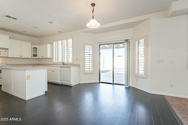 kitchen with decorative light fixtures, dark hardwood / wood-style floors, sink, white appliances, and white cabinetry