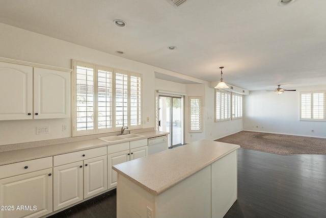 kitchen with decorative light fixtures, sink, white cabinetry, and dishwasher