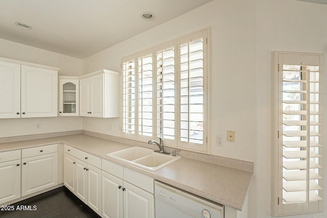 kitchen with white dishwasher, sink, white cabinets, and plenty of natural light