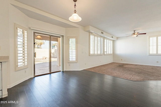 unfurnished living room featuring ceiling fan and dark wood-type flooring