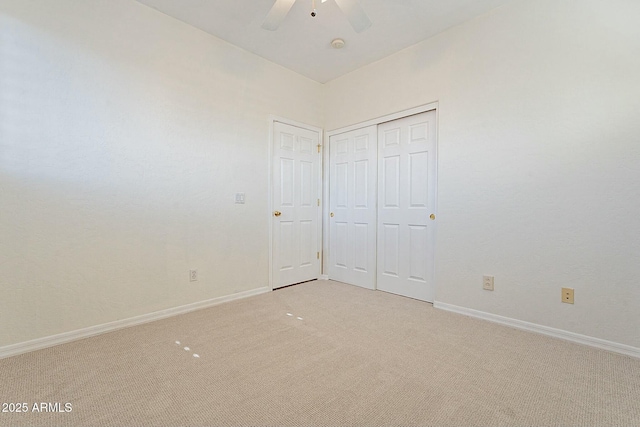 unfurnished bedroom with ceiling fan, a closet, and light colored carpet