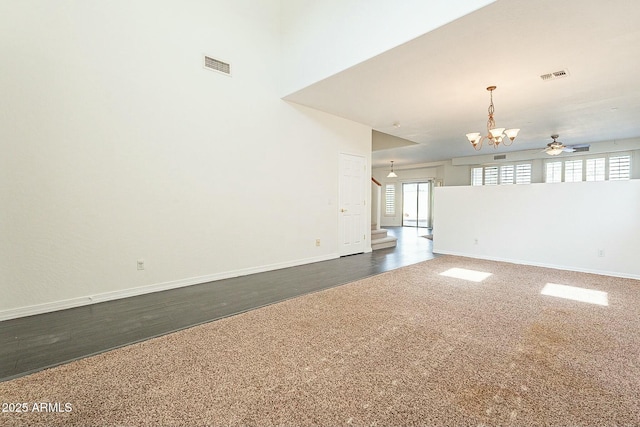 unfurnished living room featuring dark hardwood / wood-style floors and ceiling fan with notable chandelier