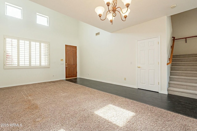 carpeted spare room with an inviting chandelier