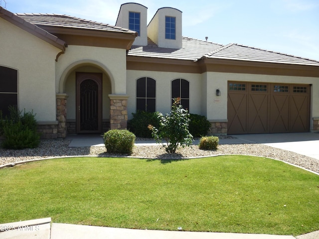 6687 S Banning St, Gilbert, AZ 85298 - view of front of property featuring stone siding, stucco siding, a garage, a front lawn, and a tile roof