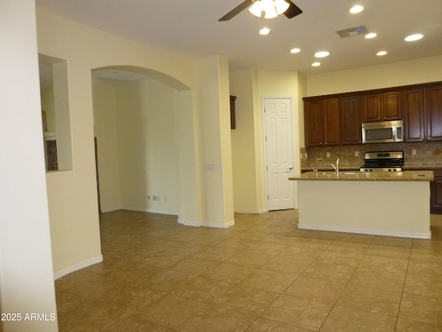 6687 S Banning St, Gilbert, AZ 85298 - kitchen featuring appliances with stainless steel finishes, ceiling fan, backsplash, arched walkways, and recessed lighting