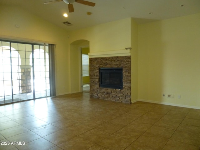 6687 S Banning St, Gilbert, AZ 85298 - unfurnished living room featuring ceiling fan, arched walkways, tile patterned flooring, a stone fireplace, and lofted ceiling