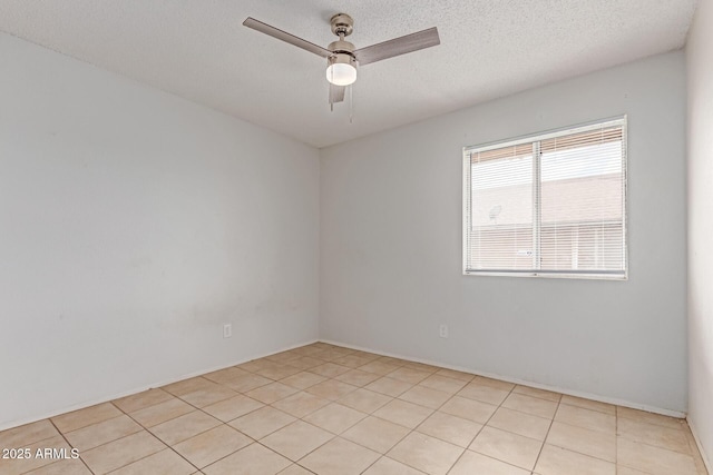 empty room featuring a ceiling fan, light tile patterned floors, and a textured ceiling
