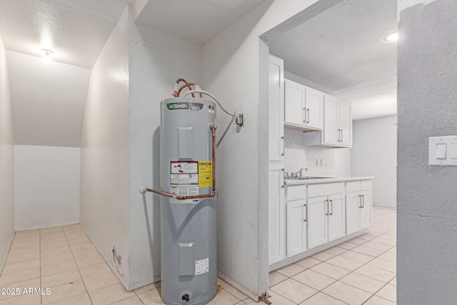 utility room with electric water heater and a sink