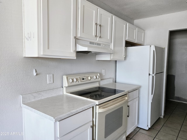 kitchen with white appliances, under cabinet range hood, light tile patterned floors, white cabinetry, and light countertops