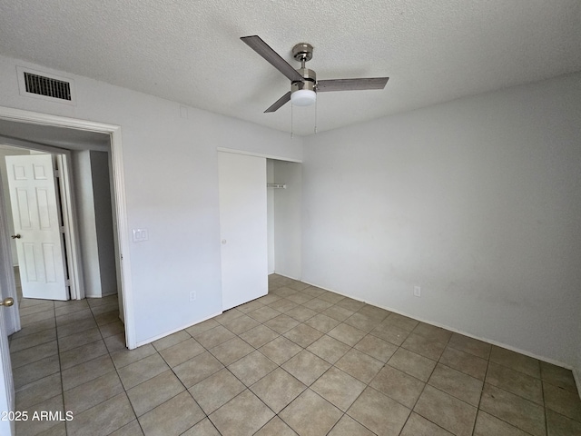 unfurnished bedroom featuring a textured ceiling, a closet, and ceiling fan