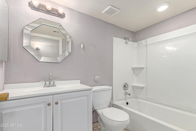 bathroom with a textured wall, vanity, toilet, and shower / tub combination