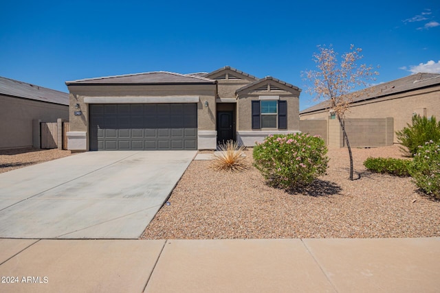 view of front of home with stucco siding, an attached garage, fence, driveway, and a tiled roof