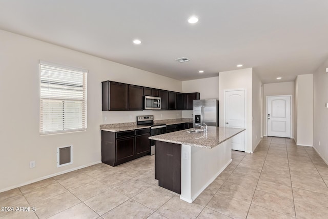 kitchen featuring a center island with sink, visible vents, appliances with stainless steel finishes, light stone countertops, and recessed lighting