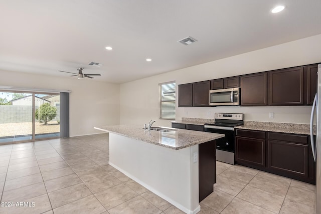 kitchen featuring appliances with stainless steel finishes, an island with sink, a sink, and visible vents