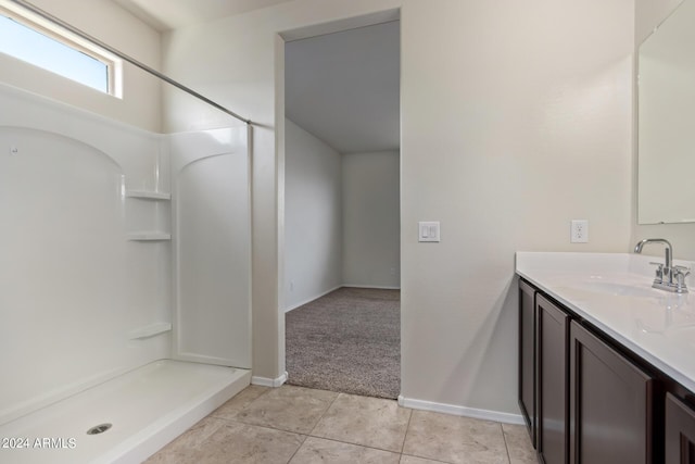 bathroom featuring baseboards, vanity, a shower stall, and tile patterned floors