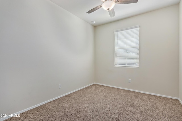empty room featuring carpet flooring, a ceiling fan, and baseboards