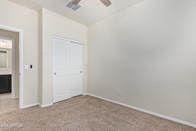 unfurnished bedroom with light carpet, a closet, visible vents, and baseboards