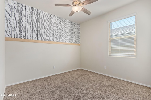 empty room with carpet floors, ceiling fan, and baseboards