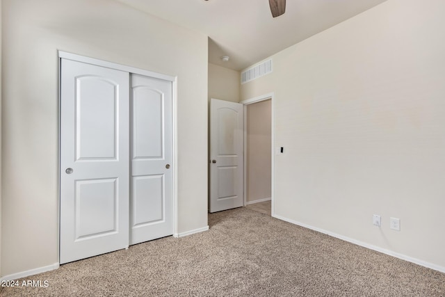 unfurnished bedroom with carpet, a closet, ceiling fan, and baseboards