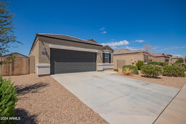 ranch-style home featuring an attached garage, fence, driveway, a residential view, and stucco siding