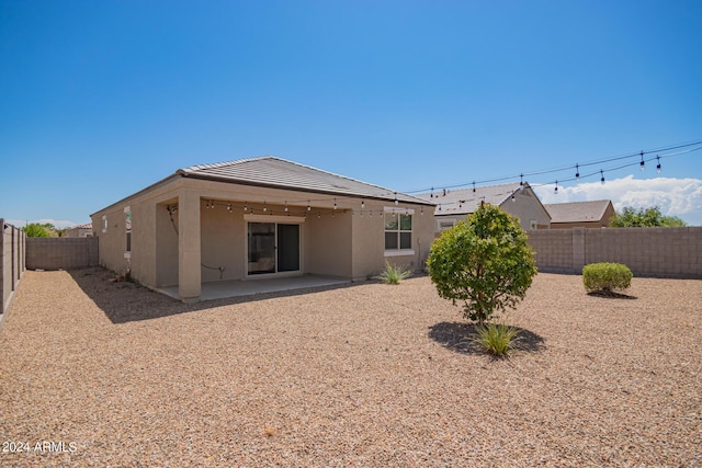 rear view of property with a patio, a fenced backyard, and stucco siding