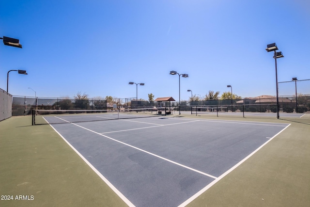 view of tennis court featuring fence
