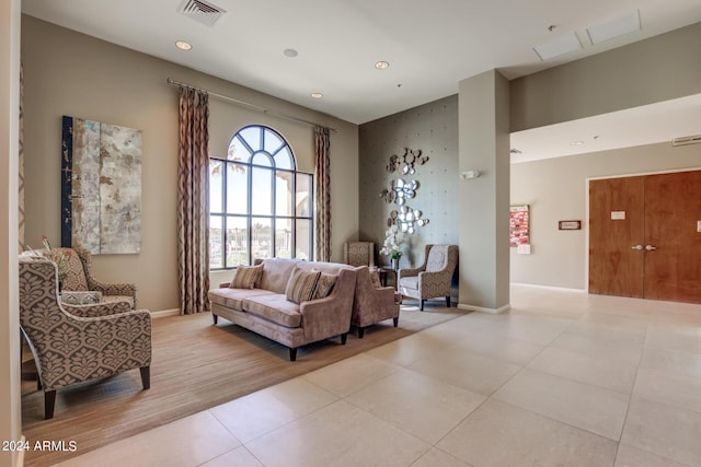 living area with light tile patterned floors, baseboards, and visible vents