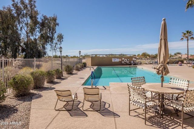 pool featuring fence and a patio