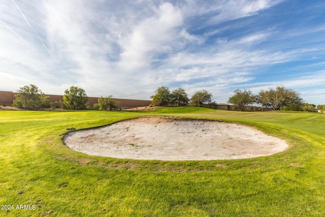 surrounding community with golf course view and a lawn
