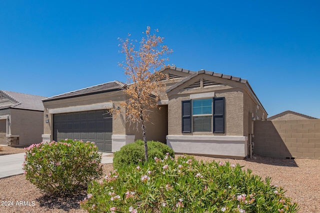 view of front of home featuring an attached garage, fence, and stucco siding