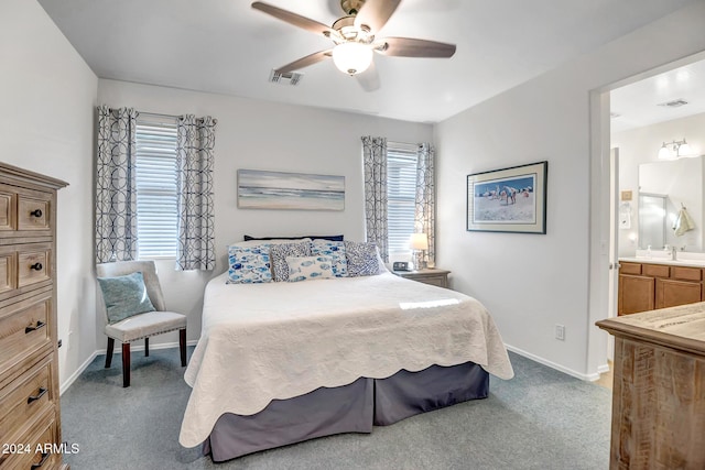 carpeted bedroom featuring connected bathroom, ceiling fan, and sink