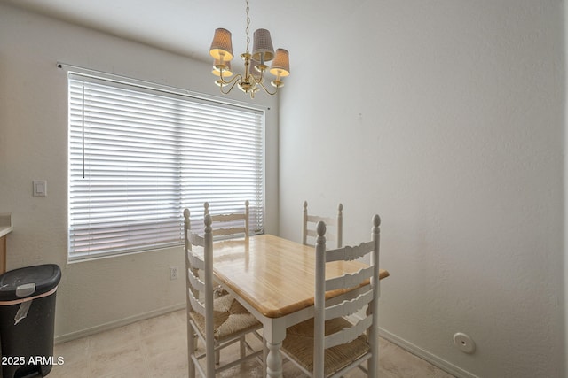 dining area featuring baseboards and an inviting chandelier