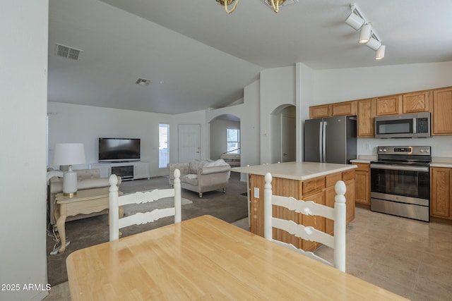 kitchen with arched walkways, lofted ceiling, stainless steel appliances, visible vents, and light countertops