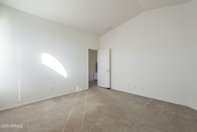 spare room with lofted ceiling and carpet flooring