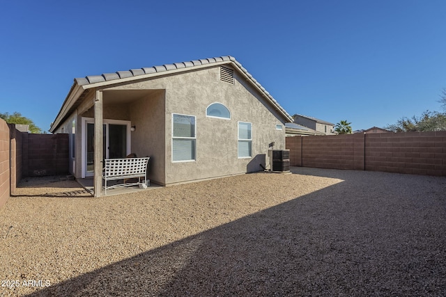 back of property with cooling unit, a fenced backyard, a patio, and stucco siding