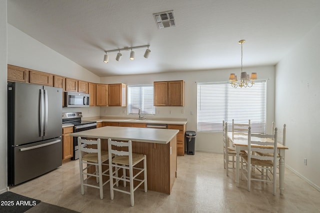 kitchen featuring a sink, visible vents, light countertops, appliances with stainless steel finishes, and brown cabinetry