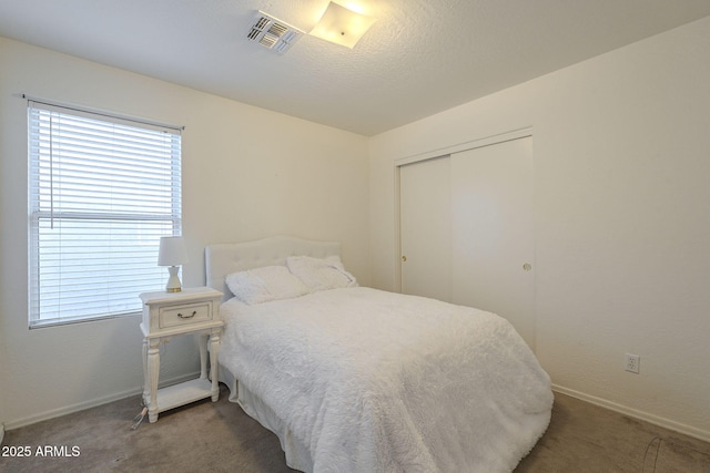 bedroom featuring a closet, visible vents, baseboards, and carpet flooring