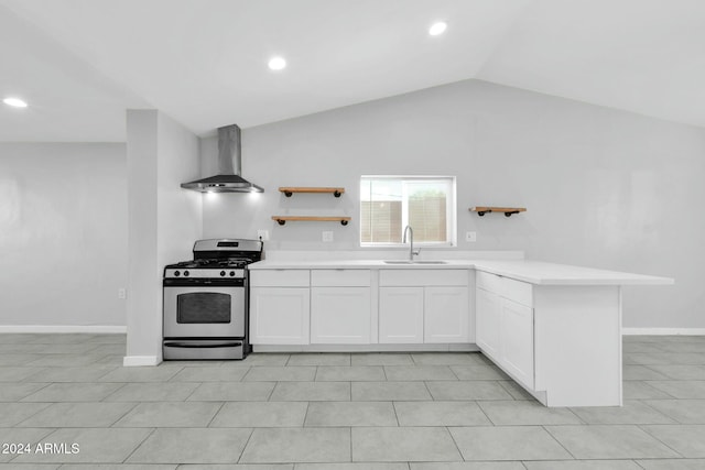 kitchen with lofted ceiling, stainless steel gas stove, white cabinetry, and wall chimney exhaust hood