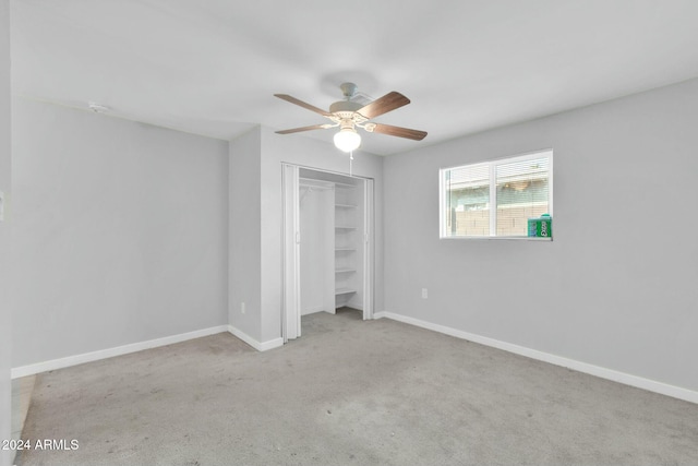 unfurnished bedroom featuring light carpet, a closet, and ceiling fan