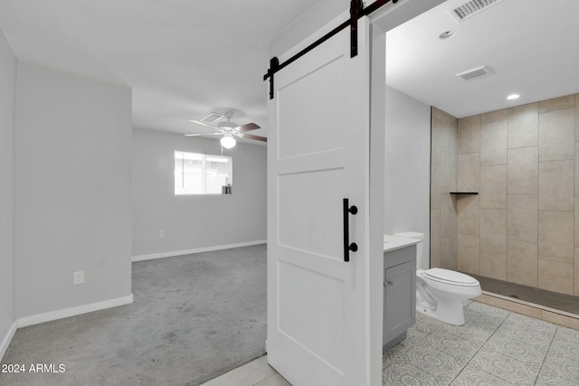 bathroom featuring vanity, tile patterned floors, ceiling fan, toilet, and a tile shower