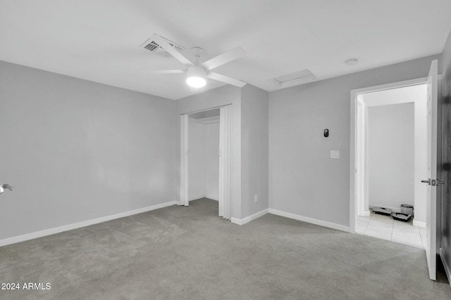 unfurnished bedroom featuring ceiling fan, light carpet, and a closet