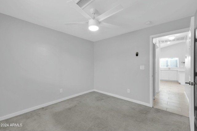 spare room featuring light colored carpet, ceiling fan, lofted ceiling, and sink