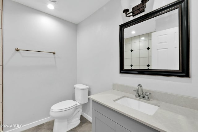 bathroom with toilet, vanity, and tile patterned floors