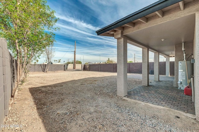 view of yard with gas water heater and a patio area