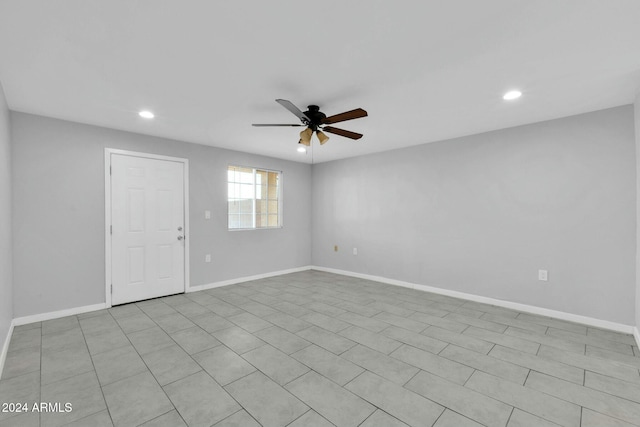 tiled empty room featuring ceiling fan