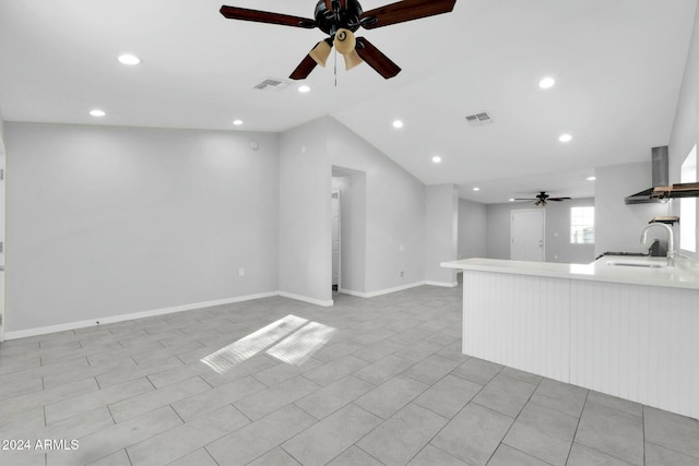 unfurnished living room with ceiling fan, sink, light tile patterned floors, and lofted ceiling