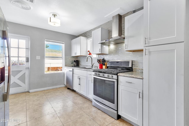 kitchen featuring white cabinets, sink, wall chimney exhaust hood, and stainless steel appliances