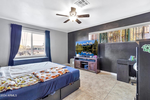 bedroom featuring ceiling fan, black refrigerator, and light tile patterned floors