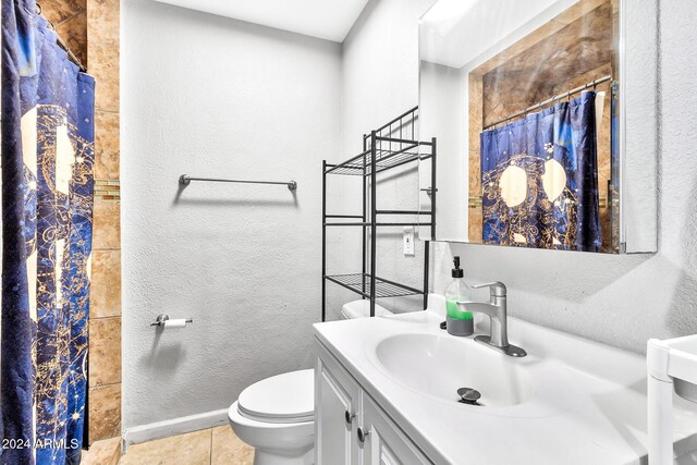 bathroom with toilet, a shower with curtain, vanity, and tile patterned floors