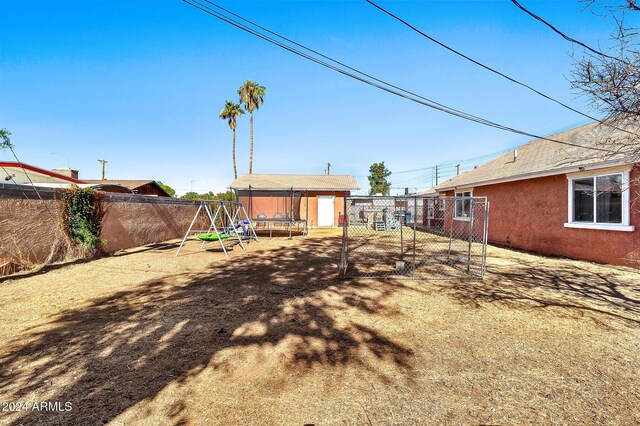 view of yard featuring a playground and a storage shed